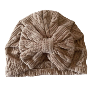 Baby wearing coco-colored Weave Bow Bonnet from Plush Bubs with detailed woven texture and bow