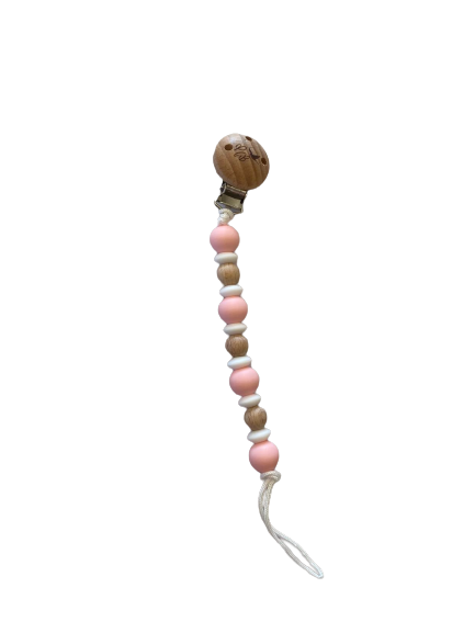 Plush Bubs Baby Pink Silicone Dummy Clip clipped to baby’s outfit